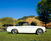 AUT 22 RK1976 01
1965 Datsun Fairlady Convertible White Low Profile View On Grass By Hills And Trees
