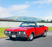 AUT 22 RK2856 01
1968 Oldsmobile 442 W-30 Convertible Red 3/4 Front View On Pavement By Grass And Mountains