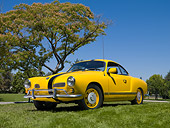 AUT 22 RK3112 01
1967 VW Karmann Ghia Coupe Yellow With Black Stripe 3/4 Front View On Grass By Tree