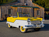 AUT 22 RK3169 01
1960 Nash Metropolitan Yellow And White 3/4 Front View On Pavement By Old Barn