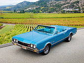 AUT 22 RK3175 01
1966 Oldsmobile 442 Light Blue 3/4 Front View On Pavement By Farm