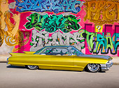 AUT 22 RK3184 01
1961 Cadillac Coupe de Ville Gold Profile View On Pavement By Wall Of Graffiti
