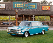 AUT 22 RK3367 01
1962 AMC Rambler Classic Blue With White Flames 3/4 Front View On Grass By General Store