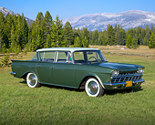 AUT 22 RK3382 01
1960 AMC Rambler Deluxe Green 3/4 Front View On Grass By Evergreen Trees And Mountain