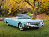 AUT 22 RK3400 01
1964 Lincoln Continental Convertible Baby Blue 3/4 Front View On Grass By Autumn Trees And Bridge