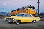 AUT 22 RK3449 01
1964 Ford Galaxie 500 XL Factory Lightweight Banana Yellow Pearl 3/4 Side View On Pavement By Train