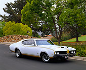 AUT 22 RK0959 02
1969 Oldsmobile Hurst 455 Gold And White 3/4 Side View On Pavement