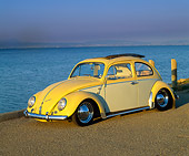 AUT 22 RK1056 01
1960 VW Beetle With Sunroof Yellow 3/4 Front View On Pavement By Water