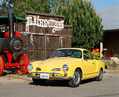 AUT 22 RK1103 02
1969 VW Karmann Ghia Yellow Front 3/4 View On Pavement By Barn And Train