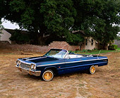 AUT 22 RK1123 02
1964 Chevy Impala SS Convertible Lowrider Blue Side 3/4 View On Dirt By Tree