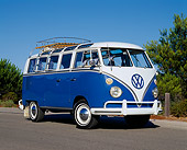 AUT 22 RK1228 03
1965 Volkswagen Deluxe 21 Window Microbus Blue And White Low 3/4 Front View On Pavement Trees Blue Sky
