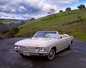 AUT 22 RK1302 11
1965 Chevrolet Corvair Corsa Convertible Beige 3/4 Front View On Pavement Grass Hills Background