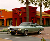 AUT 22 RK1691 04
1969 Chevrolet Malibu Green Black Top 3/4 Front View On Pavement By Buildings And Palm Trees