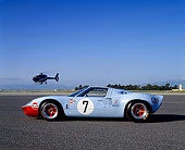 AUT 22 RK1718 03
1968 Ford GT40 Light Blue And Orange FAV Car Profile On Pavement With Helicopter Blue Sky