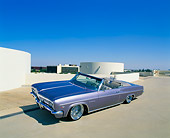 AUT 22 RK1809 02
1966 Chevy Impala Convertible Violet 3/4 Side View Raised On Pavement Blue Sky