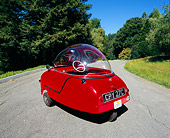 AUT 22 RK1940 01
1964 Peel Trident Microcar Red 3/4 Rear View On Pavement By Trees