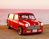 AUT 22 RK2003 01
1962 Austin Mini Traveller Woody Red White Stripes 3/4 Front View On Sand By Water