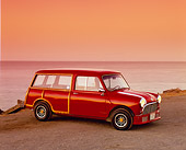 AUT 22 RK2005 02
1962 Austin Mini Traveller Woody Red With White Stripes 3/4 Front View On Sand By Ocean