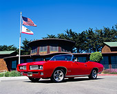AUT 22 RK2050 03
1969 Pontiac GTO Convertible Red Low 3/4 Front View On Pavement By Building Flags