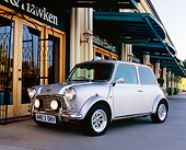 AUT 22 RK2062 02
1969 Rover Mini Silver With White Stripes 3/4 Front View On Pavement By Building
