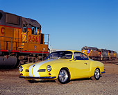AUT 22 RK2123 01
1961 VW Karmann Ghia Yellow White Stripe 3/4 Front View On Gravel By Train