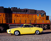 AUT 22 RK2124 02
1961 VW Karmann Ghia Yellow White Stripe 3/4 Side View On Gravel By Train