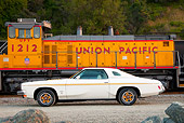 AUT 23 BK0040 01
1973 Oldsmobile Cutlass White And Gold Stripe Profile View On Gravel By Train