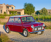 AUT 23 BK0048 01
1975 Morris Mini 1000 Red 3/4 Front View On Gravel By House