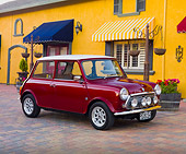 AUT 23 BK0050 01
1975 Morris Mini 1000 Red 3/4 Front View On Brick Road By Yellow Building