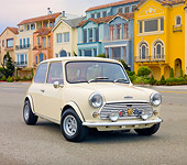 AUT 23 BK0063 01
1971 Mini 1000 Cream 3/4 Front View On Pavement By Colorful Houses