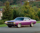 AUT 23 RK0163 03
1970 Dodge Challenger Plum Crazy 3/4 Side View On Pavement By Trees Headlights On