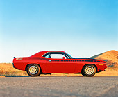 AUT 23 RK0172 02
1970 Plymouth AAR Cuda Red And Black Profile On Pavement By Dry Grass Blue Sky