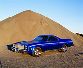 AUT 23 RK0733 03
1977 Chevy El Camino Blue  Front 3/4 View By Pile Of Sand Blue Sky