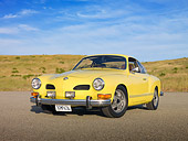 AUT 23 RK1989 01
1973 VW Karmann Ghia Coupe Yellow 3/4 Front View On Pavement By Grassy Hill