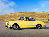 AUT 23 RK1990 01
1973 VW Karmann Ghia Coupe Yellow 3/4 Side View On Pavement By Grassy Hill