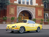 AUT 23 RK1991 01
1973 VW Karmann Ghia Coupe Yellow 3/4 Front View On Pavement By Building