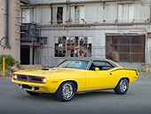 AUT 23 RK2009 01
1970 Plymouth Barracuda 440 Six Pack Yellow 3/4 Front View On Pavement By Old Factory Building