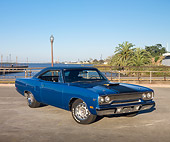 AUT 23 RK2014 01
1970 Plymouth Road Runner Hemi Blue With Black Stripe 3/4 Front View On Pavement By Water And Palm Trees