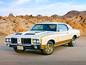 AUT 23 RK2082 01
1972 Hurst Oldsmobile Cutlass White And Gold 3/4 Front View On Pavement By Rocks
