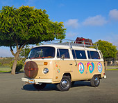 AUT 23 RK2158 01
1974 Volkswagen Type 2 Tan With Hippie Logos 3/4 Front View On Pavement By Trees