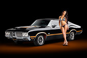 AUT 23 RK2189 01
1970 Oldsmobile 442 W-30 Black With Gold Stripes 3/4 Front View In Studio With Swimsuit Model