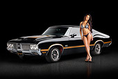 AUT 23 RK3371 01
1970 Oldsmobile W-30 442 Black With Gold Stripes 3/4 Front View On Pavement With Swimsuit Model