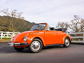 AUT 23 BK0002 01
1974 Volkswagen Cabriolet Orange Peel 3/4 Front View On Pavement By White Fence And Hills