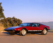 AUT 23 RK0124 06
1974 De Tomaso Pantera GTS Maroon And Black 3/4 Front View On Pavement By Trees Mountains Blue Sky