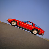 AUT 23 RK0306 05
1971 Iso Grifo Red Slanted Side View On Pavement Hill Blue Sky