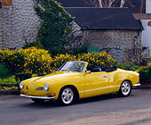 AUT 23 RK0411 01
1971 VW Karmann Ghia Convertible Yellow 3/4 Side View On Pavement By House