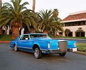 AUT 23 RK0432 01
1979 Lincoln Continental Lowrider Blue Raised 3/4 Front View On Pavement By Palm Trees And Building