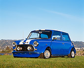 AUT 23 RK0490 02
1974 Austin Mini Cooper Blue White Stripe Low 3/4 Front View On Grass Blue Sky