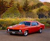 AUT 23 RK0520 01
1972 Chevrolet Nova Street Rod Orange 3/4 Front View On Dirt By Bushes And Trees