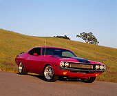 AUT 23 RK0568 02
1970 Dodge Challenger RT Pink Black Stripe 3/4 Front View On Pavement By Grass Hill